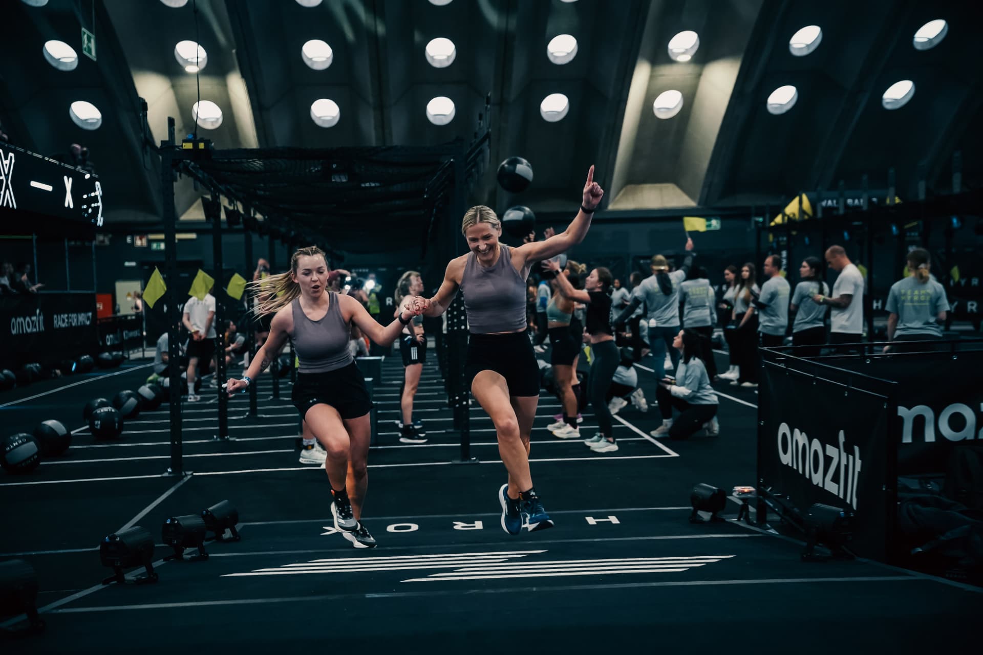Two athletes jumping together at the finish line
